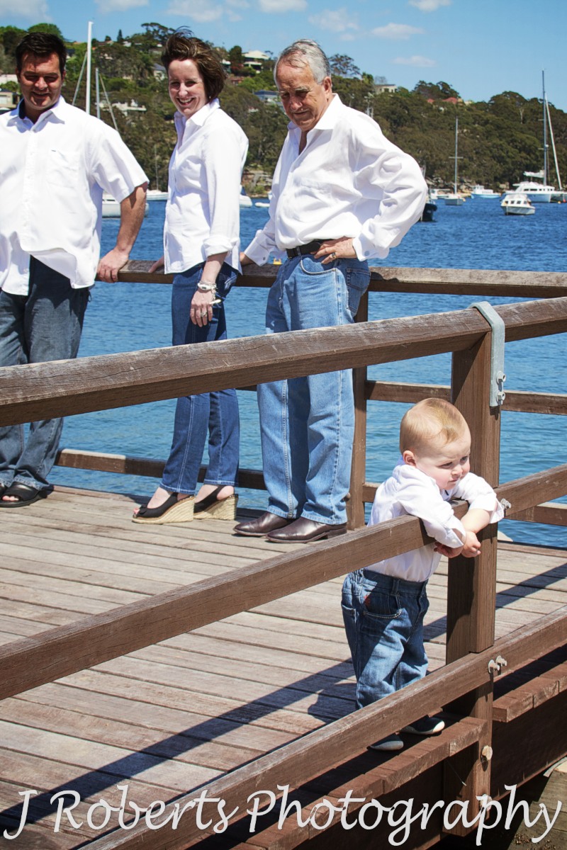 Little boy leaning over railing looking at water - family portrait photography sydney